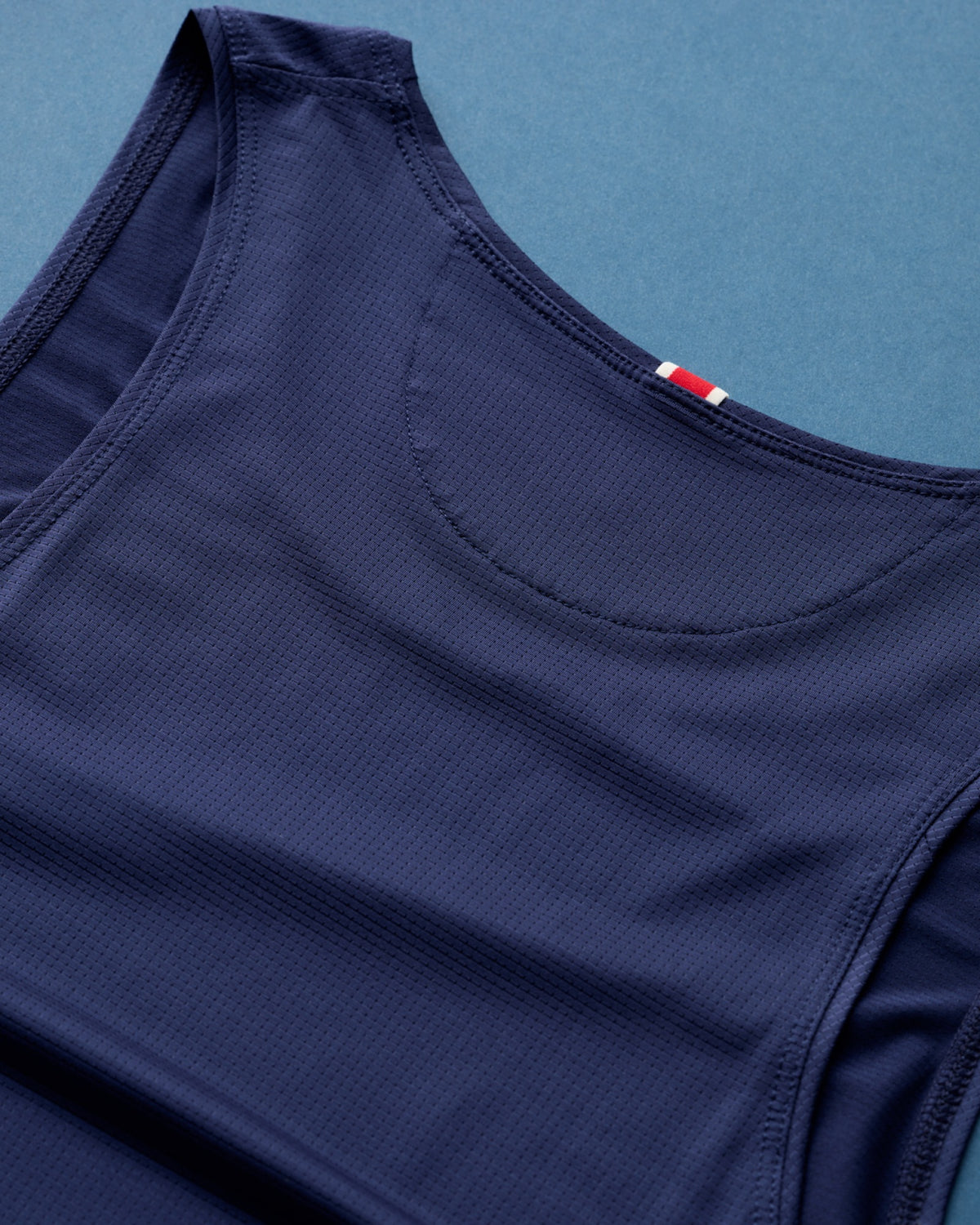 Neckline and armhole trim detail on the Tracksmith Twilight Tank